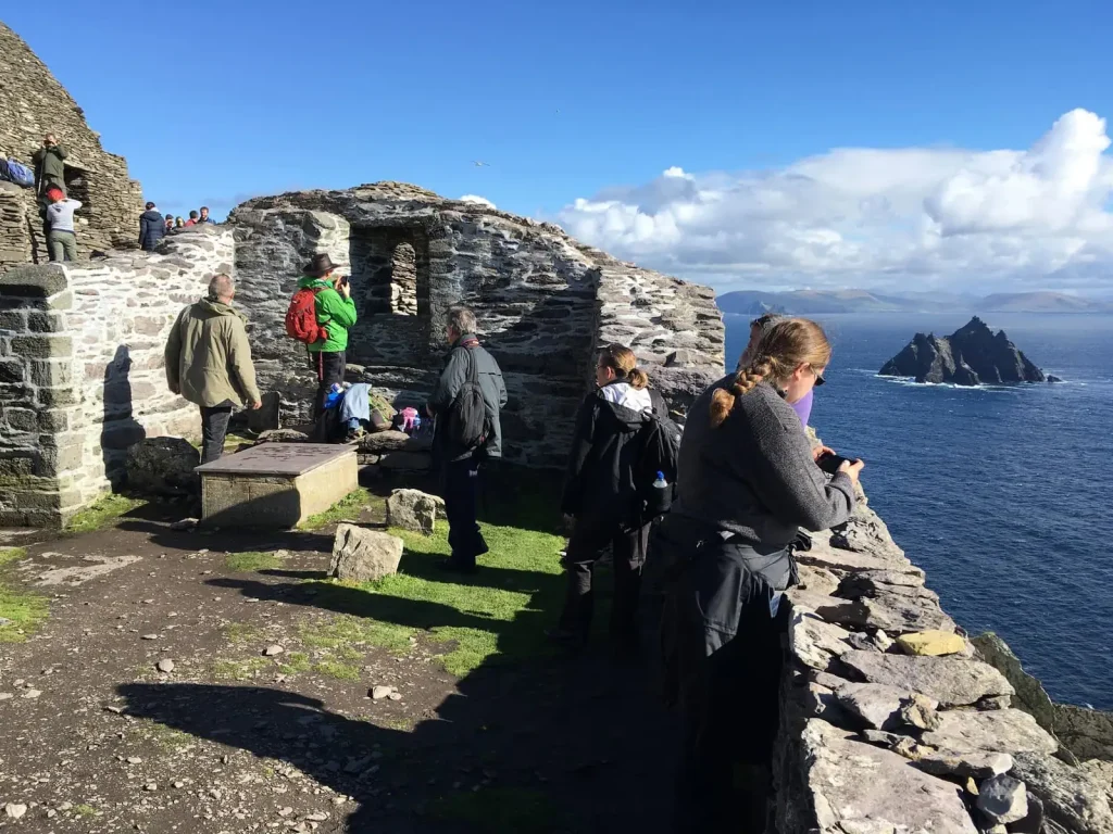 Visitors at the 6th century monastery on Skellig Michael with the Atlantic Ocean behind