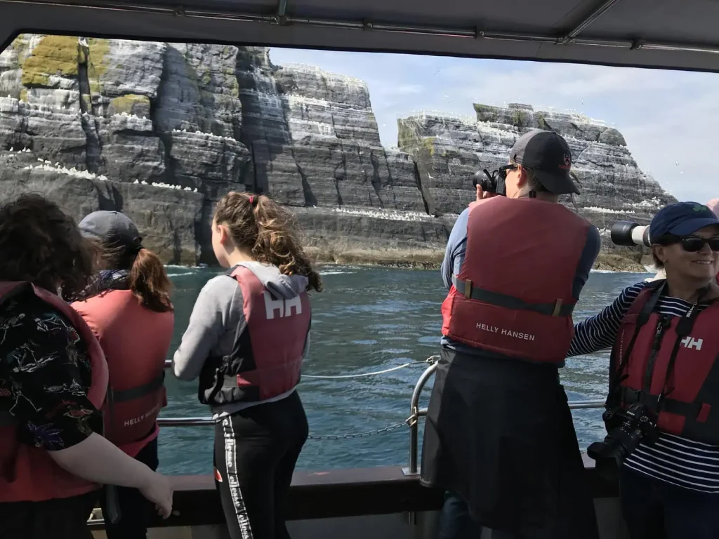 Compare Skellig Tours Passengers on a Sea Tour boat looking at Little Skellig